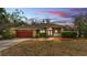 Charming home with a well-manicured lawn, mature trees, and a two-car garage at 7741 Merrily Way, Lakeland, FL 33809