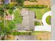 Aerial view of a home with a well-manicured lawn, circular driveway, and mature landscaping at 865 E Mann Rd, Bartow, FL 33830