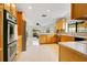 Open kitchen with stainless steel appliances, wood cabinets, and seamless view into adjacent living room at 865 E Mann Rd, Bartow, FL 33830