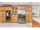 Bright kitchen features stainless steel appliances, abundant wood cabinetry, and cream tile floors at 865 E Mann Rd, Bartow, FL 33830