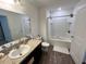 Clean bathroom featuring a sink with dark cabinets, bathtub with shower, and a toilet at 879 Grandin St, Davenport, FL 33837