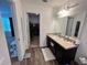 Bathroom featuring modern vanity with granite countertops and a view to a large walk-in closet at 879 Grandin St, Davenport, FL 33837