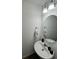 Stylish half bathroom featuring an oval mirror, modern vanity, and elegant fixtures at 879 Grandin St, Davenport, FL 33837