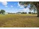 Vast backyard includes lawn, firepit with chairs, storage building, and view of rear of house at 8909 N Campbell Rd, Lakeland, FL 33810