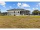 The fenced-in backyard boasts a lawn and a view of the home's screened-in patio area at 8909 N Campbell Rd, Lakeland, FL 33810