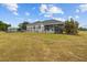 Fenced backyard featuring a screened porch with a manicured lawn and mature tree at 8909 N Campbell Rd, Lakeland, FL 33810