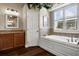 Bright bathroom with a soaking tub, wood-look floors, and granite countertops at 8909 N Campbell Rd, Lakeland, FL 33810