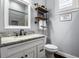 This bathroom features grey walls, granite counters, a vanity, and wall shelves at 8909 N Campbell Rd, Lakeland, FL 33810