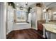 Large bathroom featuring a tub, shower, granite counters, and wood-look flooring at 8909 N Campbell Rd, Lakeland, FL 33810