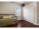 Bedroom with wood floors featuring a twin bed, closet with sliding doors, and a shuttered window at 8909 N Campbell Rd, Lakeland, FL 33810