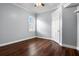Empty bedroom with wood floors featuring light blue walls, white trim, and a shuttered window at 8909 N Campbell Rd, Lakeland, FL 33810