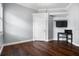 Empty bedroom with wood floors, a wall-mounted TV, and a small desk at 8909 N Campbell Rd, Lakeland, FL 33810