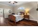 Bedroom with wood floors featuring a queen bed, shuttered window, and light walls with white trim at 8909 N Campbell Rd, Lakeland, FL 33810