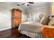 Bedroom featuring hardwood floors, a cozy bed, and a classic wooden armoire at 8909 N Campbell Rd, Lakeland, FL 33810