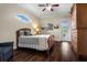 Cozy bedroom featuring a queen bed, wood floors, an exterior access door, and a charming arched window at 8909 N Campbell Rd, Lakeland, FL 33810