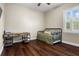 Bedroom with wood floors featuring a twin bed, desk, shuttered window, and light walls with white trim at 8909 N Campbell Rd, Lakeland, FL 33810