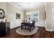 Traditional dining room with hardwood floors, and a dark wood table set with blue chairs under a chandelier at 8909 N Campbell Rd, Lakeland, FL 33810