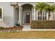 Charming front entry showcases a decorative door, lush landscaping, and classic architectural details at 8909 N Campbell Rd, Lakeland, FL 33810