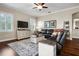 Cozy living room with hardwood floors, ceiling fan, modern entertainment center, and comfortable seating at 8909 N Campbell Rd, Lakeland, FL 33810