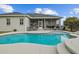 Inviting in-ground pool with screened-in lanai and outdoor seating area for relaxation at 8909 N Campbell Rd, Lakeland, FL 33810