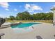 Backyard swimming pool with a spa area surrounded by well-maintained landscaping and a black metal fence at 8909 N Campbell Rd, Lakeland, FL 33810