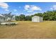 Backyard of a home with a shed, mature trees, and a well-maintained lawn at 8909 N Campbell Rd, Lakeland, FL 33810