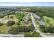 Aerial shot of the property nestled within a lush, green neighborhood with mature trees and manicured lawns at 1001 Lena Run Ct, Winter Haven, FL 33880