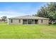 Expansive backyard featuring a covered patio, lush lawn, and privacy with ample space for outdoor activities at 1001 Lena Run Ct, Winter Haven, FL 33880