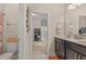 Bright bathroom with double sinks, dark cabinetry, and a view into the hallway at 1001 Lena Run Ct, Winter Haven, FL 33880