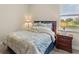 Inviting bedroom with blue accents, a bedside table, and a bright window view at 1001 Lena Run Ct, Winter Haven, FL 33880