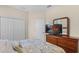 Bedroom with a wooden dresser, a large TV, and soft, neutral decor at 1001 Lena Run Ct, Winter Haven, FL 33880