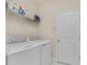 Functional laundry area equipped with modern appliances and shelving for storage and organization at 1001 Lena Run Ct, Winter Haven, FL 33880