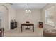 Comfortable office space with neutral walls, carpet flooring, a window and a stylish light fixture at 1001 Lena Run Ct, Winter Haven, FL 33880