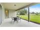 Covered patio area with outdoor seating overlooking a lush green lawn and serene surroundings at 1001 Lena Run Ct, Winter Haven, FL 33880