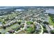 Aerial view showcases a lovely community with mature trees, a tranquil pond, and a distant lake at 1056 Rally Dr, Polk City, FL 33868