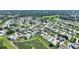 Wide aerial view captures a peaceful neighborhood with lush landscaping and a charming pond at 1056 Rally Dr, Polk City, FL 33868