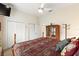 Comfortable bedroom featuring a large bed, ceiling fan, multiple closets, and an antique-style wardrobe at 1056 Rally Dr, Polk City, FL 33868