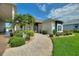 Picture-perfect home boasts lush landscaping, a welcoming front porch, and mature trees at 1056 Rally Dr, Polk City, FL 33868