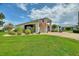 Charming home featuring a well-manicured lawn, mature landscaping, and a welcoming facade at 1056 Rally Dr, Polk City, FL 33868