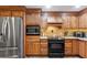 Kitchen featuring wood cabinets, stainless refrigerator, built in microwave, and smooth top electric range at 1056 Rally Dr, Polk City, FL 33868