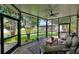 Screened lanai with comfortable seating, a ceiling fan, and peaceful backyard views at 1056 Rally Dr, Polk City, FL 33868