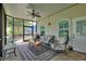 Screened lanai with cozy seating, ceiling fan, and views of the landscaped yard for outdoor living at 1056 Rally Dr, Polk City, FL 33868