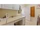 Functional laundry room with built-in desk area and ample cabinet space for storage at 1056 Rally Dr, Polk City, FL 33868