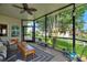 Inviting screened-in porch with neutral furniture, ceiling fan, and a tranquil view of the surrounding landscape at 1056 Rally Dr, Polk City, FL 33868