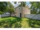 Spacious backyard featuring lush green grass, mature trees, and a white fence at 1105 Watersedge Dr, Lakeland, FL 33801