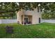 Green backyard with patio, white fence, and mature shade trees with grill at 1105 Watersedge Dr, Lakeland, FL 33801