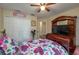 Bedroom featuring a ceiling fan, closet, and television atop dark wood furniture at 1105 Watersedge Dr, Lakeland, FL 33801