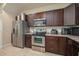 Modern kitchen featuring stainless steel appliances, stylish dark wood cabinetry, and ample countertop space at 1105 Watersedge Dr, Lakeland, FL 33801