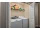 Laundry room with a modern washer and dryer and storage shelving at 1105 Watersedge Dr, Lakeland, FL 33801