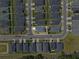 Aerial view of home in a neighborhood showing gray roofs, green lawns, and paved streets under a partly cloudy sky at 1106 Tropea Ln, Auburndale, FL 33823